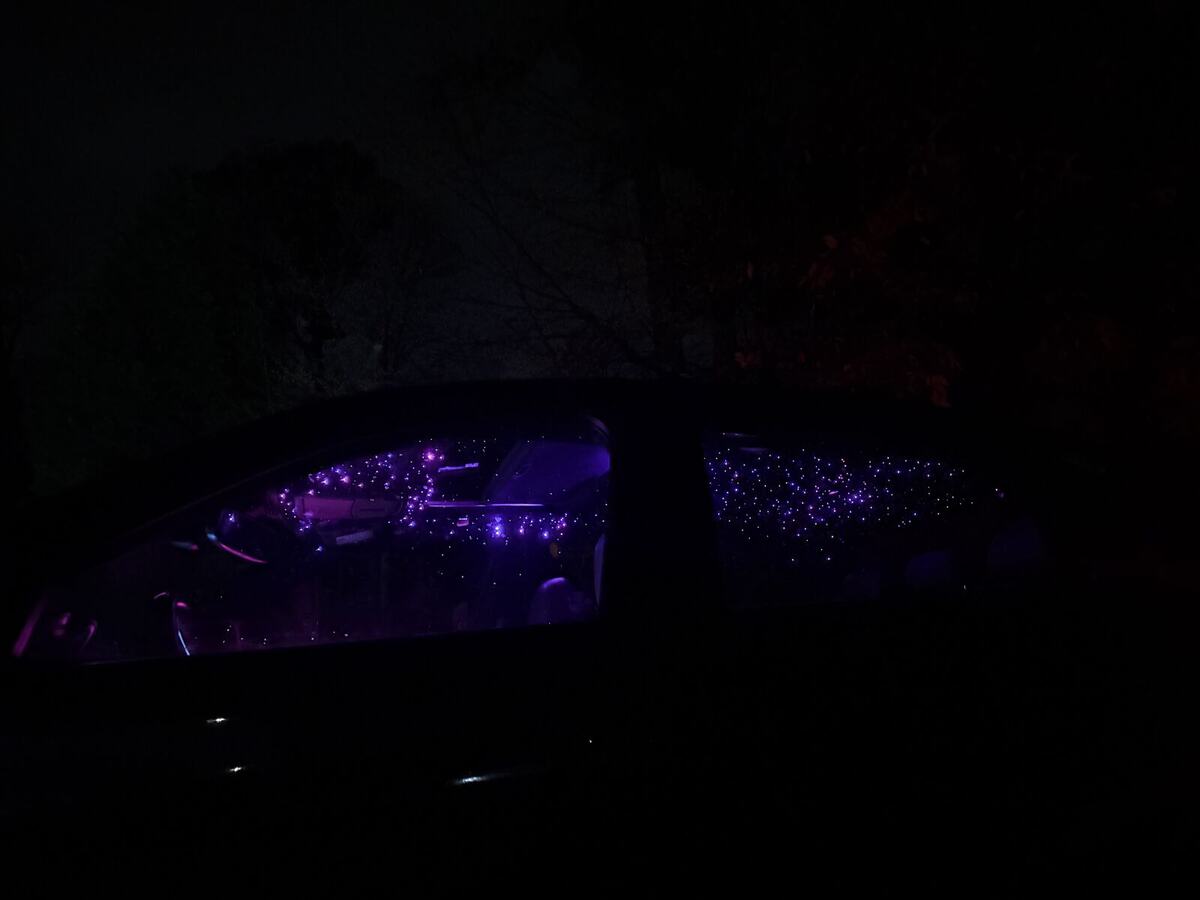 Purple stars visible through the side windows of a car at night